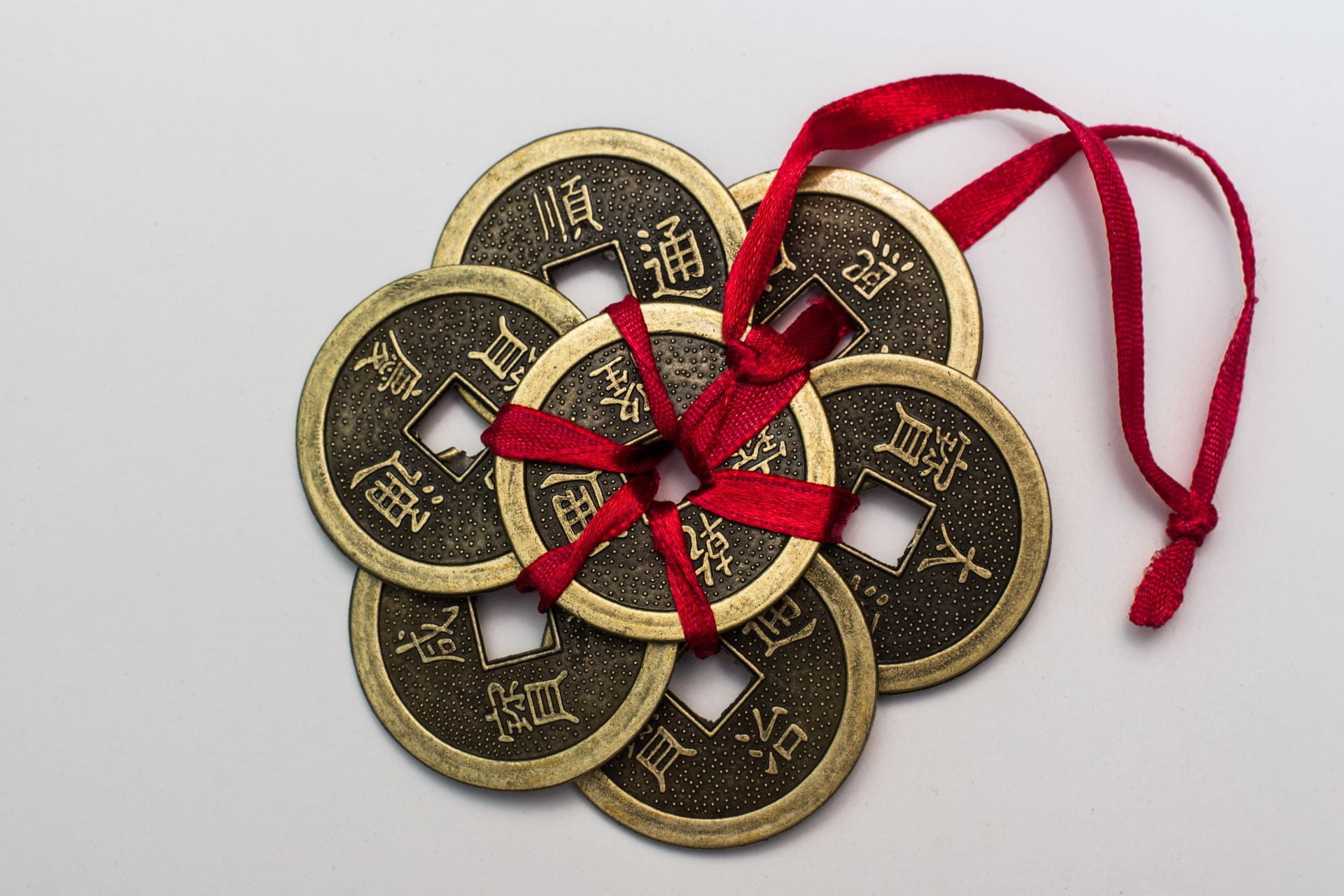 Seven iron rings with Chinese characters in gold and a red ribbon tied on the center ring on the left.