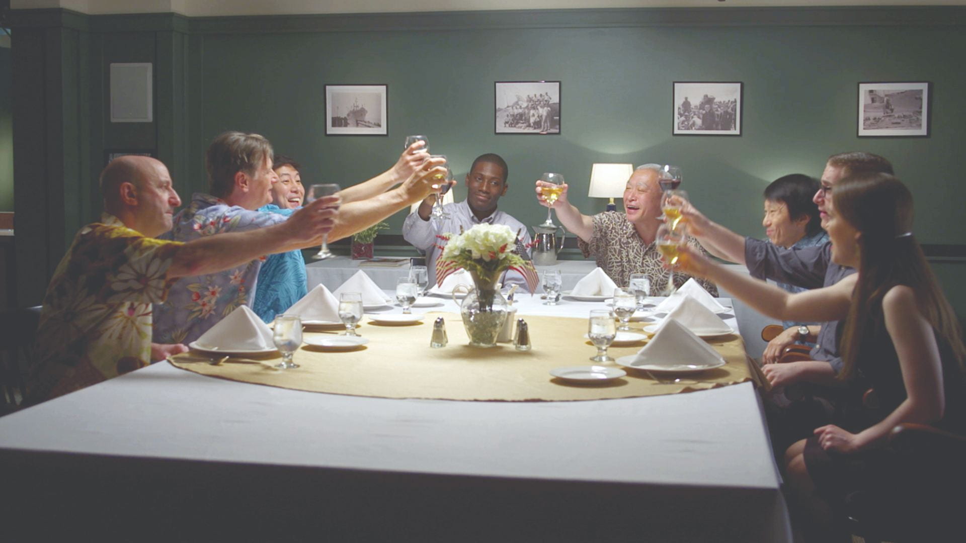 A group of friends at raising their glasses at a dinner table
