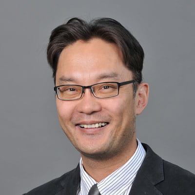 Headshot of Taku Suzuki in professional attire