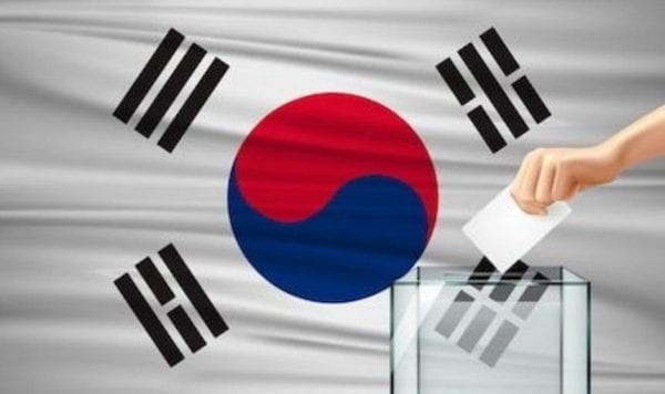 South Korean flag with hand placing a ballot in a box